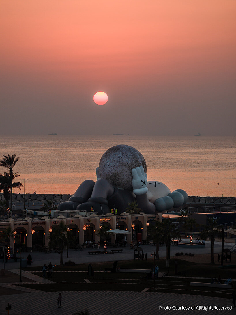 32-meter companion by KAWS lifts glowing moon along abu dhabi's waterfront