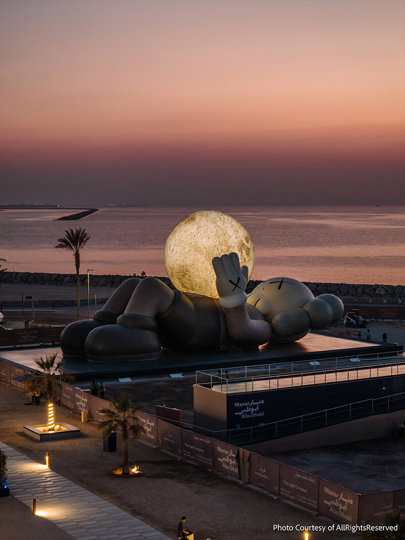 32-meter companion by KAWS lifts glowing moon along abu dhabi's waterfront