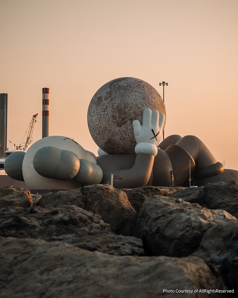 32-meter companion by KAWS lifts glowing moon along abu dhabi's waterfront