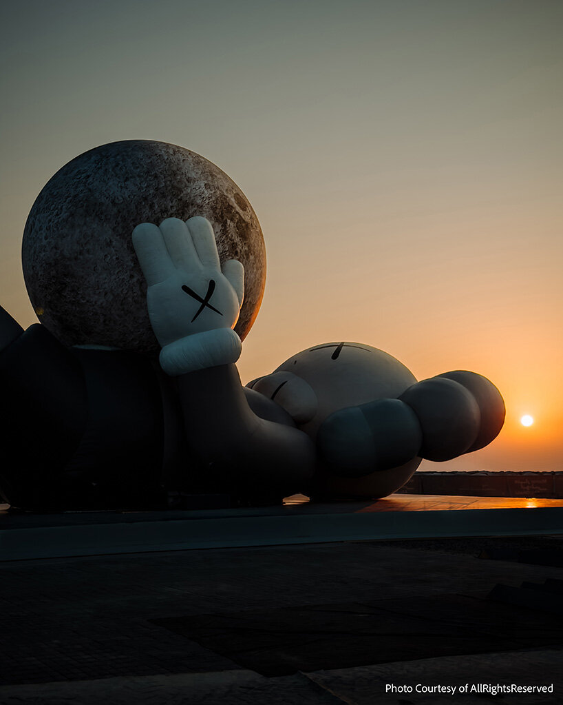 32-meter companion by KAWS lifts glowing moon along abu dhabi's waterfront