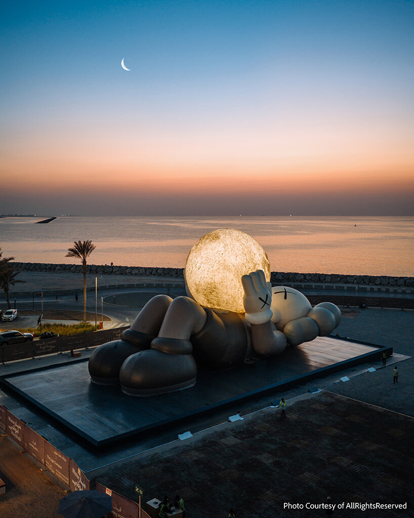 32-meter companion by KAWS lifts glowing moon along abu dhabi's waterfront