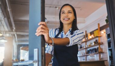women in apron opening a door to a business
