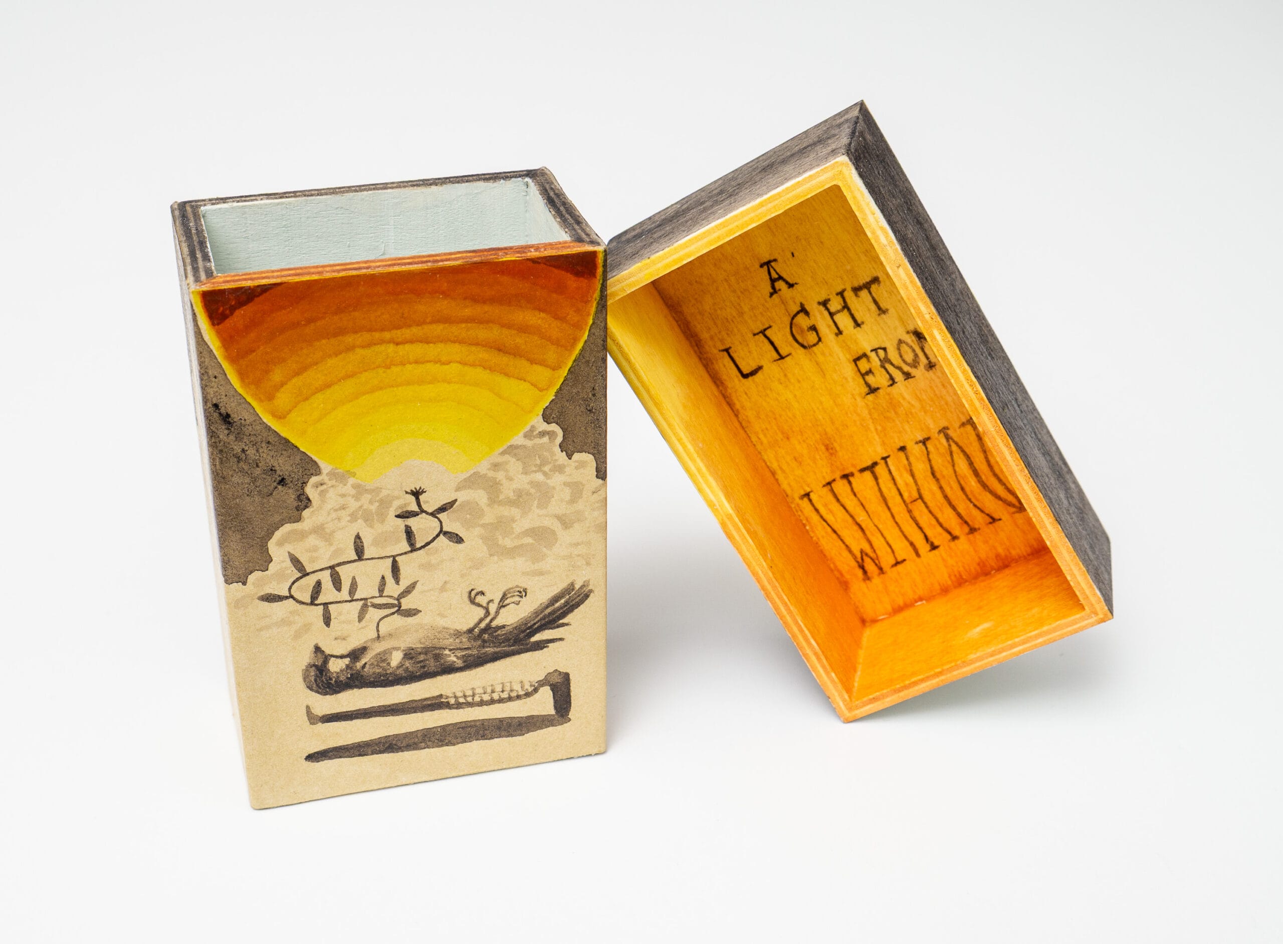 a matchbox by Graham Franciose of a bird, sun, and text that reads "a light from within"
