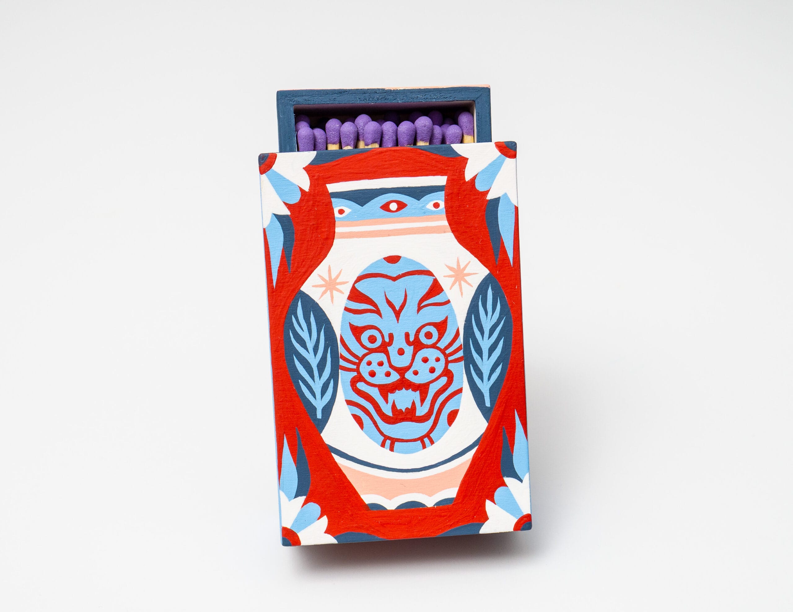 a matchbox work by Stevie Shao with a vibrant vase with a cat face painted on the front