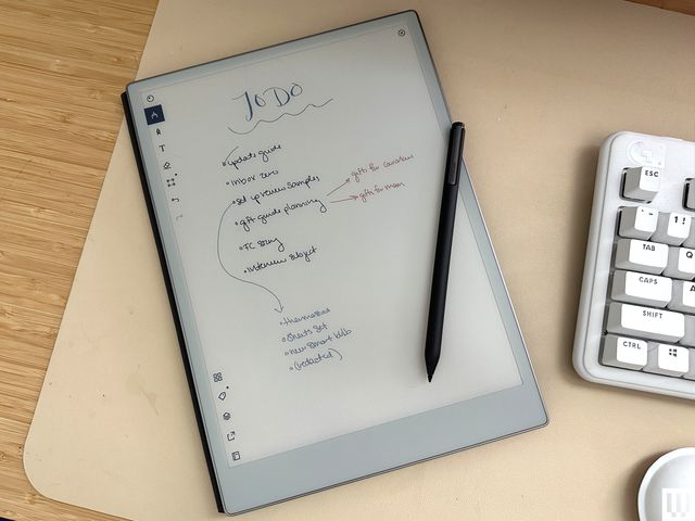Overhead view of digital notebook with handwritten scribbles on the screen and a stylus on top