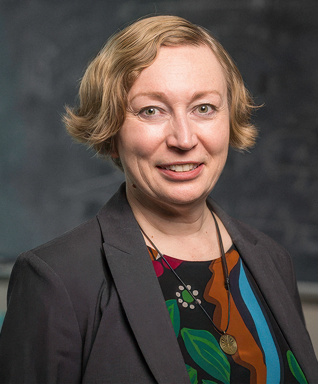 A portrait of a woman with short blond hair.