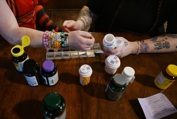 Jayla Hunt, 17, left, and her mother, Katie Gallegos, sort Jayla's vitamins and medications into a weekly pill organizer at their home in Colorado Springs on Oct. 27, 2025. (Photo by RJ Sangosti/The Denver Post)