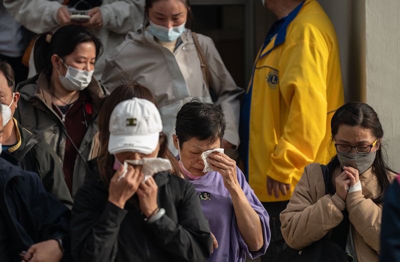 People with missing family members react after checking photographs of the deceased in Tai Po, Hong Kong. Photograph: Lam Yik Fei/New York Times
                      