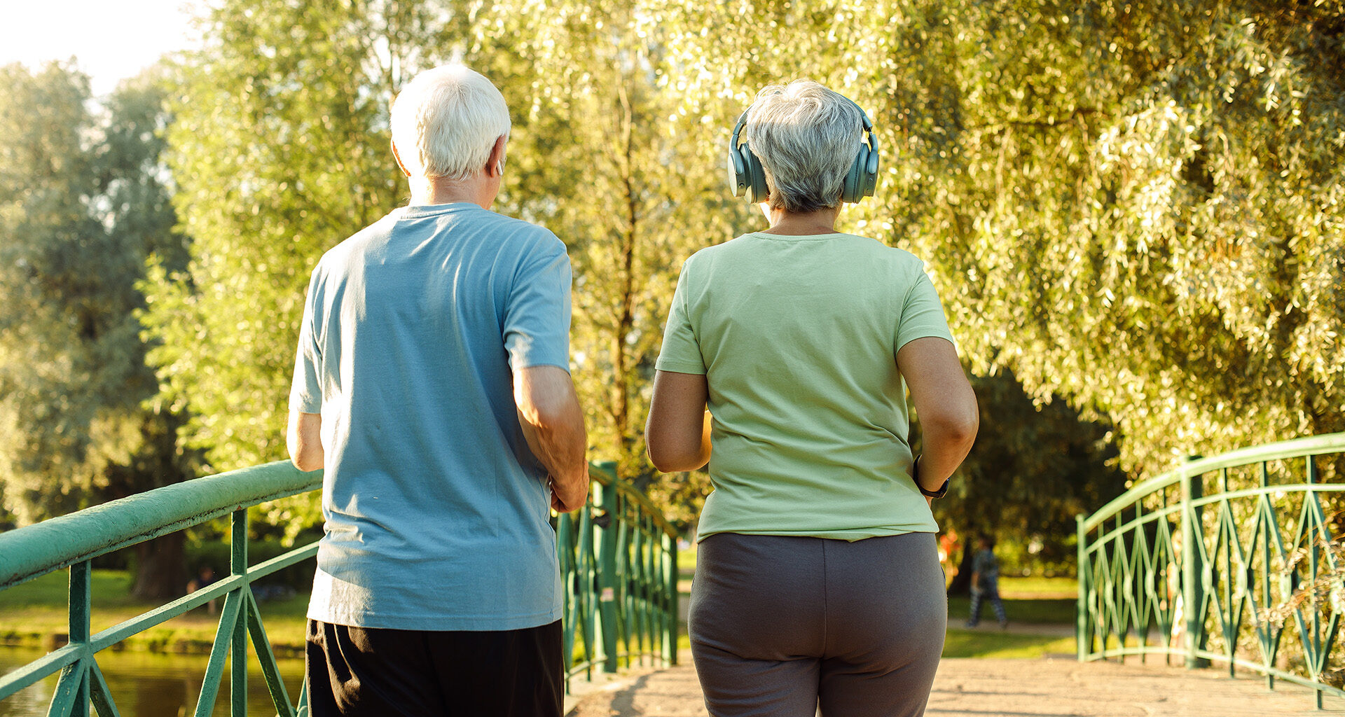 Older adults walk briskly in the park.