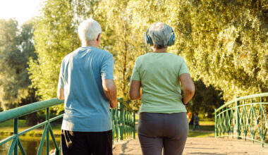 Older adults walk briskly in the park.