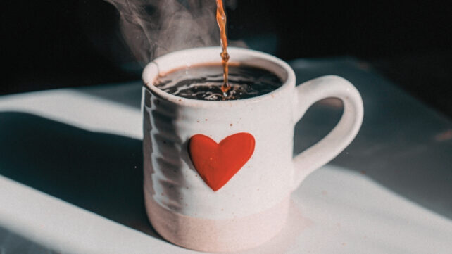 coffee pouring into a mug with a heart on it