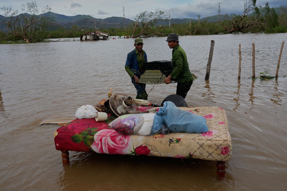People recover belongings from a home flooded by Hurricane Melissa in Santiago de Cuba. Photo: AP