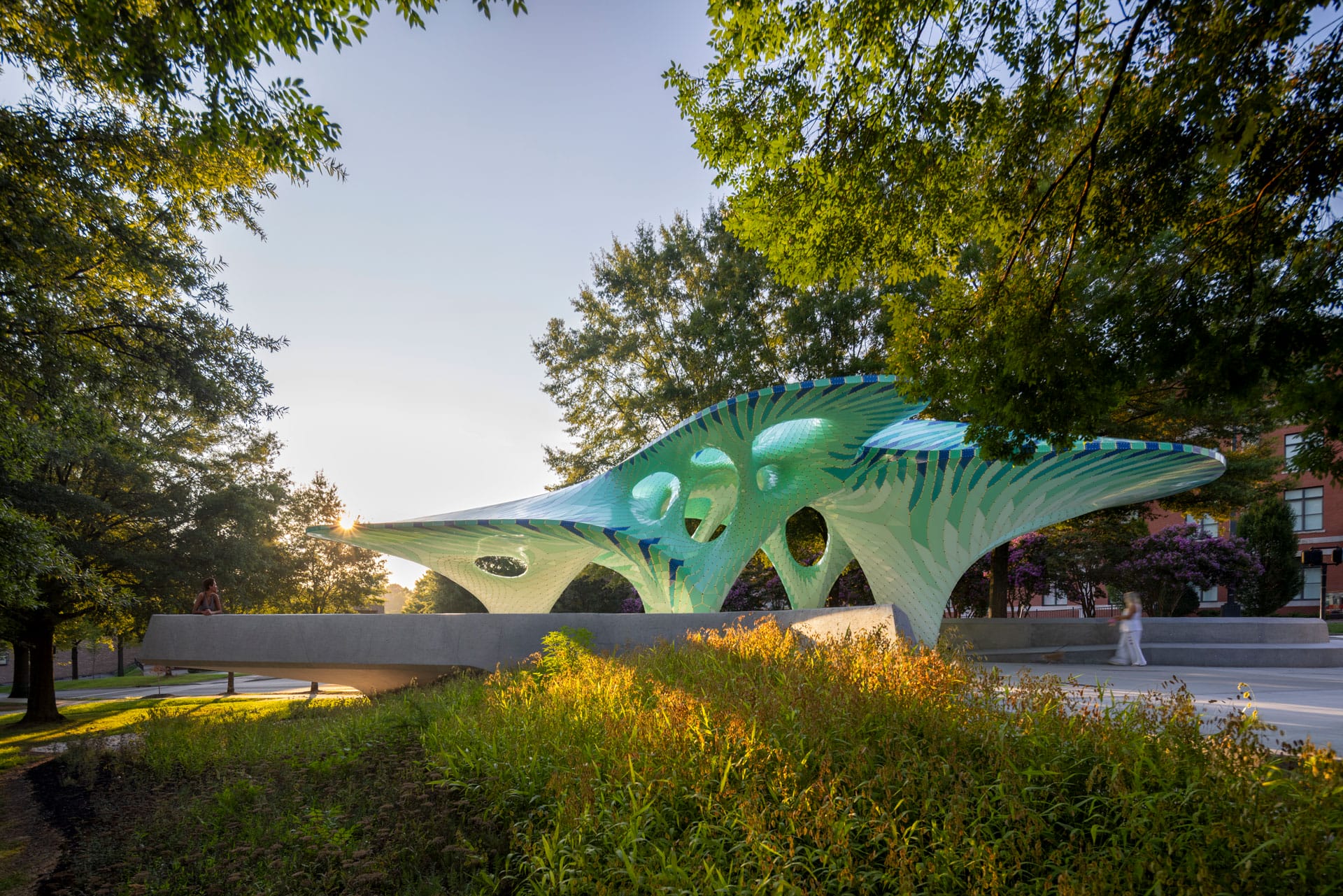 a contemporary, teal-colored pavilion designed by Marc Fornes/THEVERYMANY in a public square in Knoxville, Tennessee
