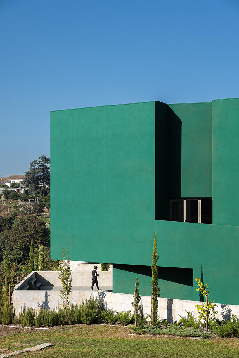 green cork skin camouflages galeria gabinete's portuguese cultural center into its lush setting