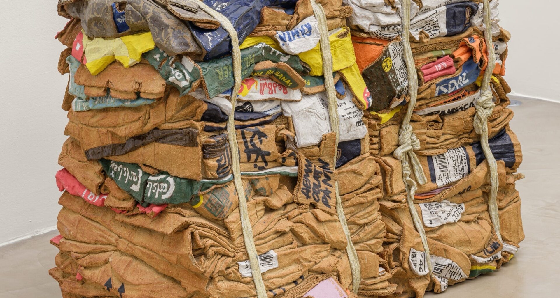 a sculpture by Ninon Hivert made of clay and other materials that mimics two compressed stacks of cardboard boxes