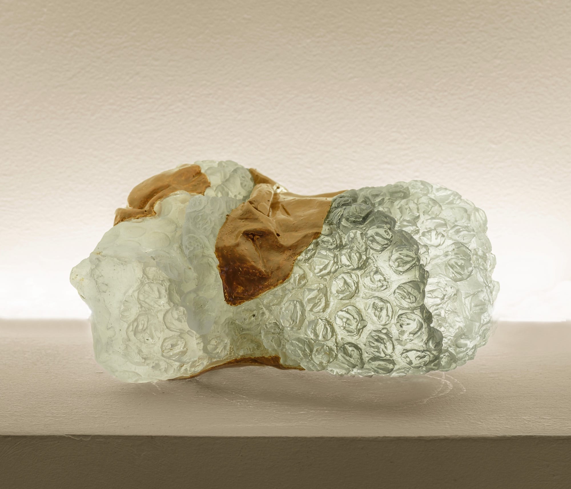 a glass sculpture by Ninon Hivert of a bubble-wrapped parcel with packing tape