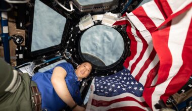 NASA astronaut and Expedition 73 Flight Engineer Jonnny Kim poses for a portrait with the American flag on the Fourth of July, or Independence Day, inside the International Space Station's "window to the world," the cupola. The orbital outpost was soaring 268 miles above a cloudy Atlantic Ocean at the time of this photograph.