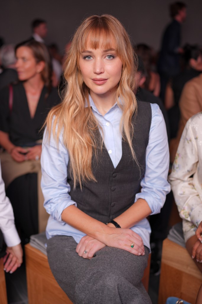 Jennifer Lawrence in a blue shirt and gray vest at the Christian Dior fashion show.