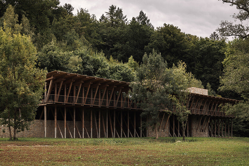 local stone and timber shape self-sufficient riverbank house by BC architects in belgium
