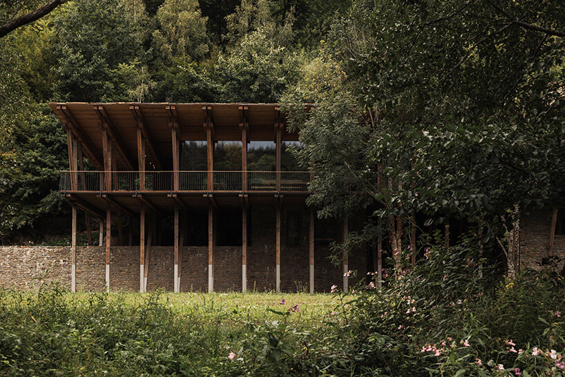 local stone and timber shape self-sufficient riverbank house by BC architects in belgium
