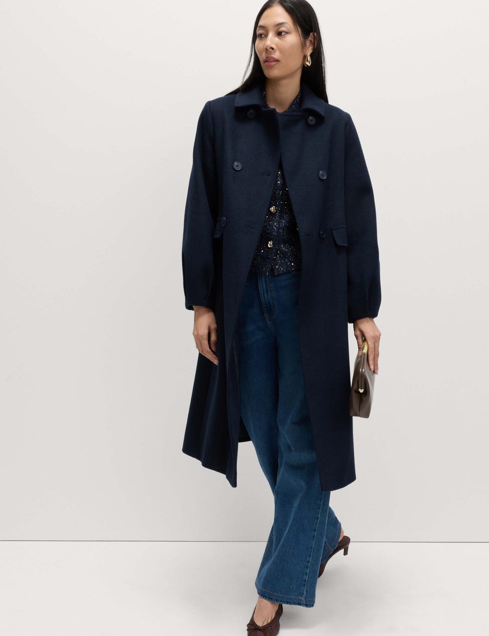 A model showcases a stylish outfit featuring a dark coat and wideleg jeans m&s navy winter coat