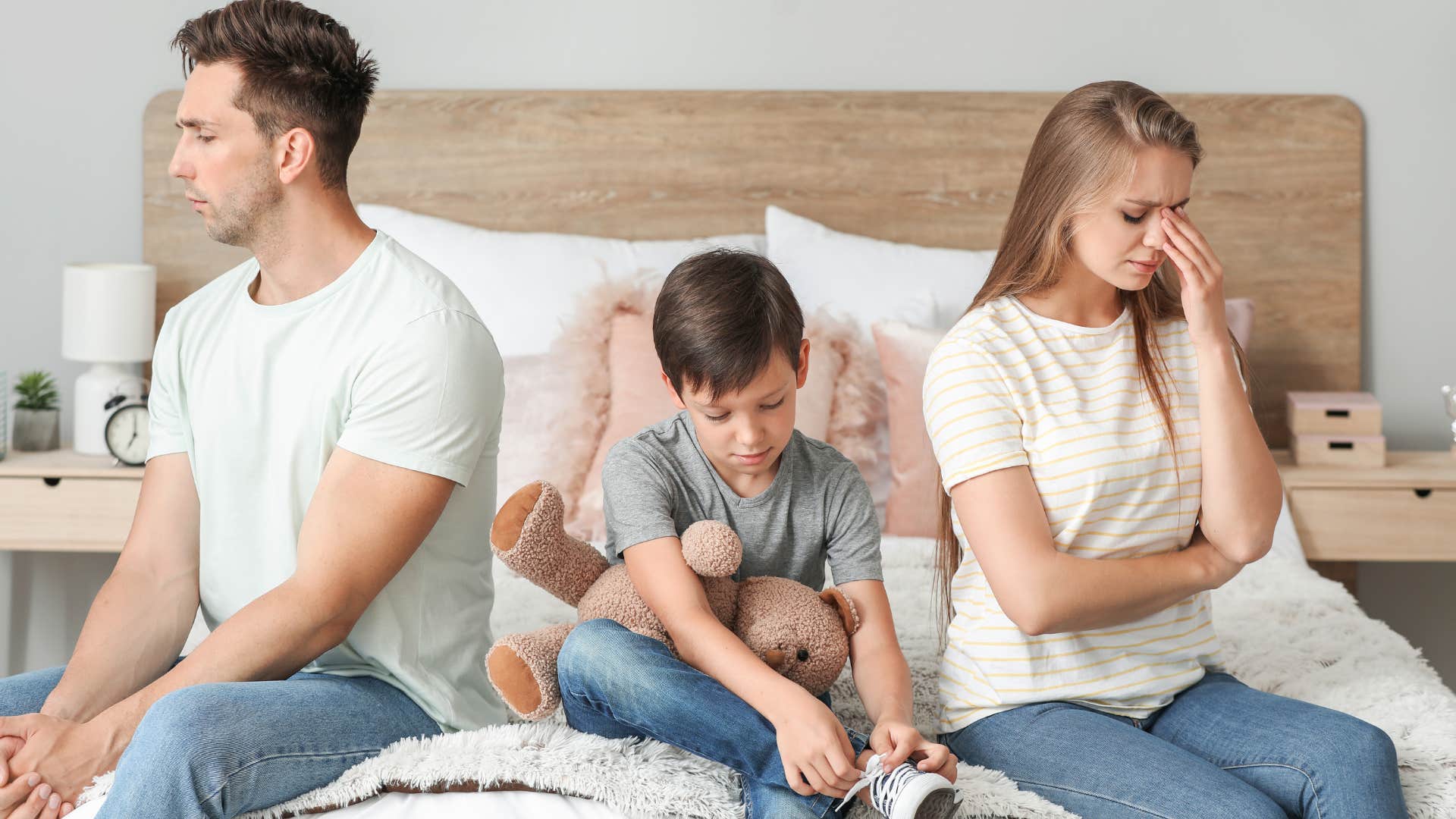 financially stressed couple sad at having to share a room with kid
