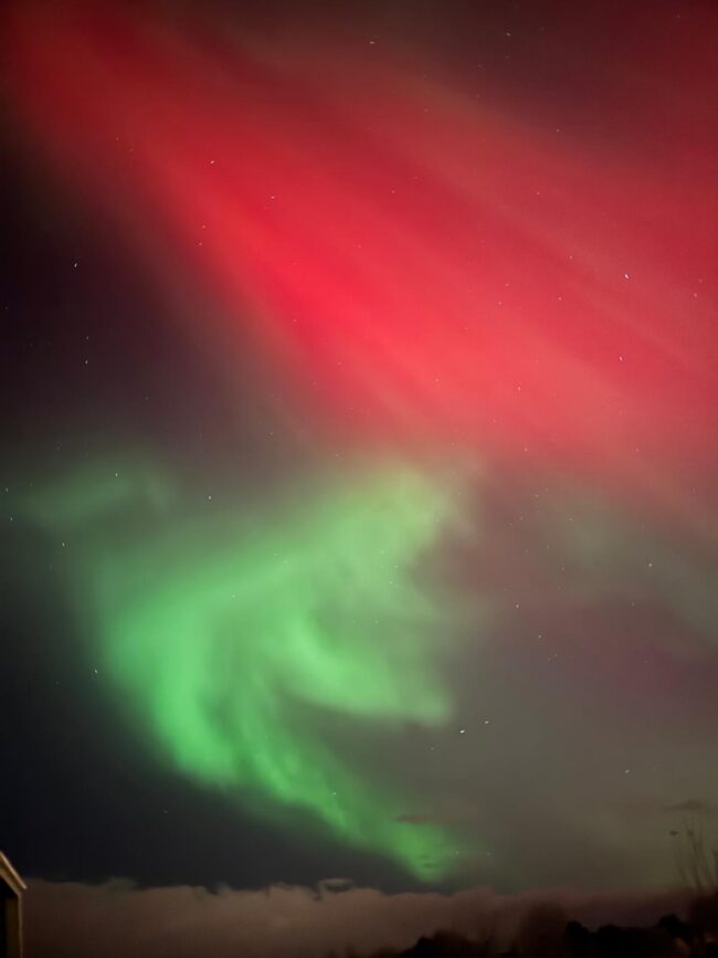 Red aurora with a bright green curling blob below.