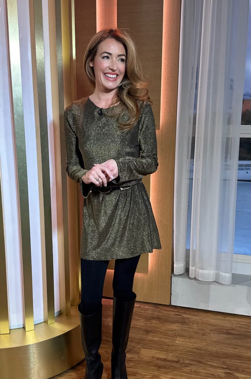cat deeley in a stylish shimmering dress standing in a modern setting