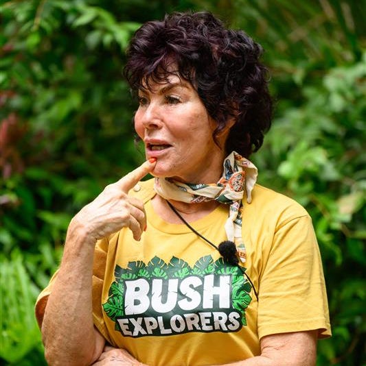 a person in a yellow shirt with bush explorers written on it surrounded by lush greenery a person in a yellow shirt with bush explorers written on it surrounded by lush greenery