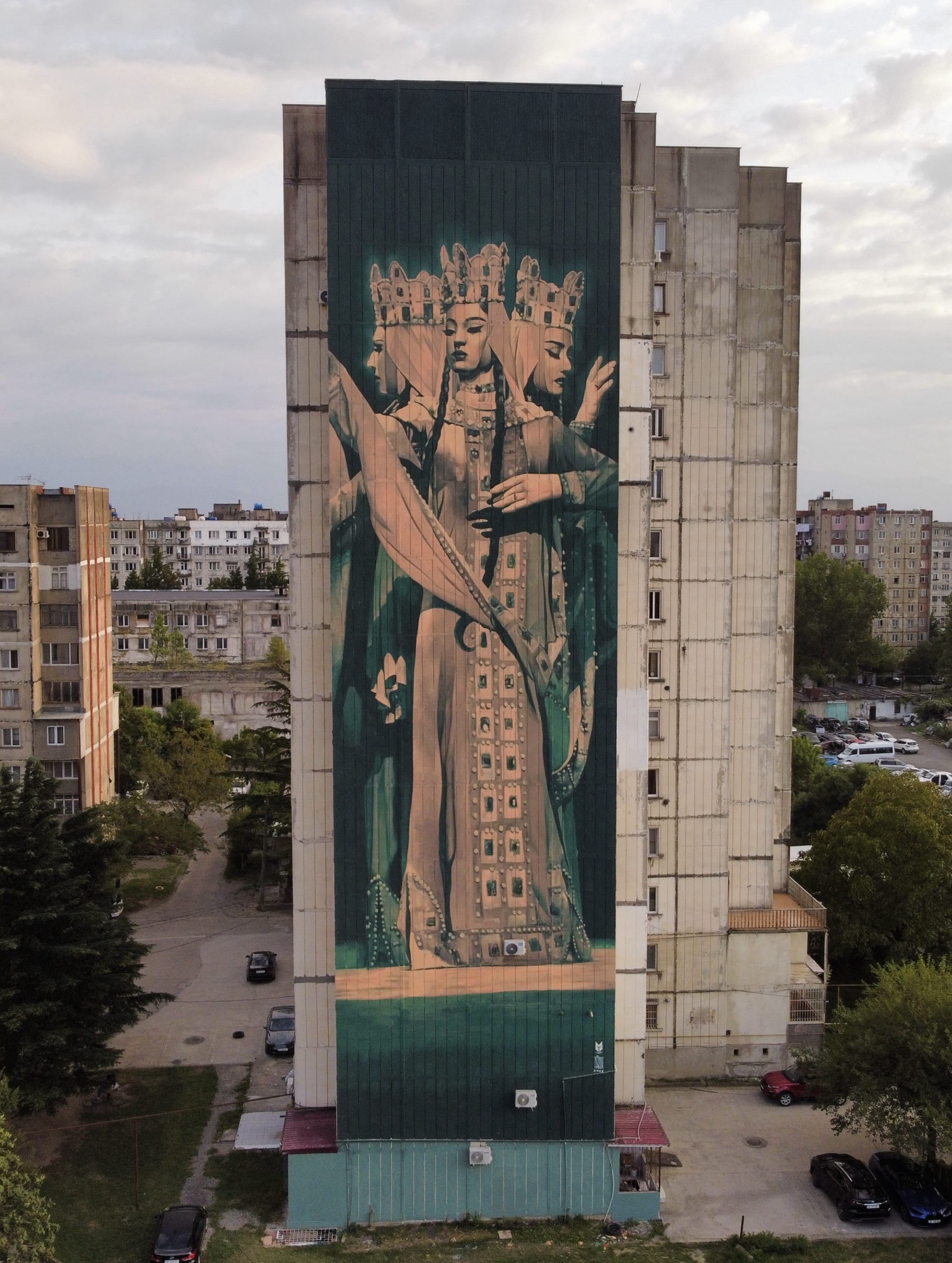 a tall mural on the side of a building of a Christian figure known as Samaya