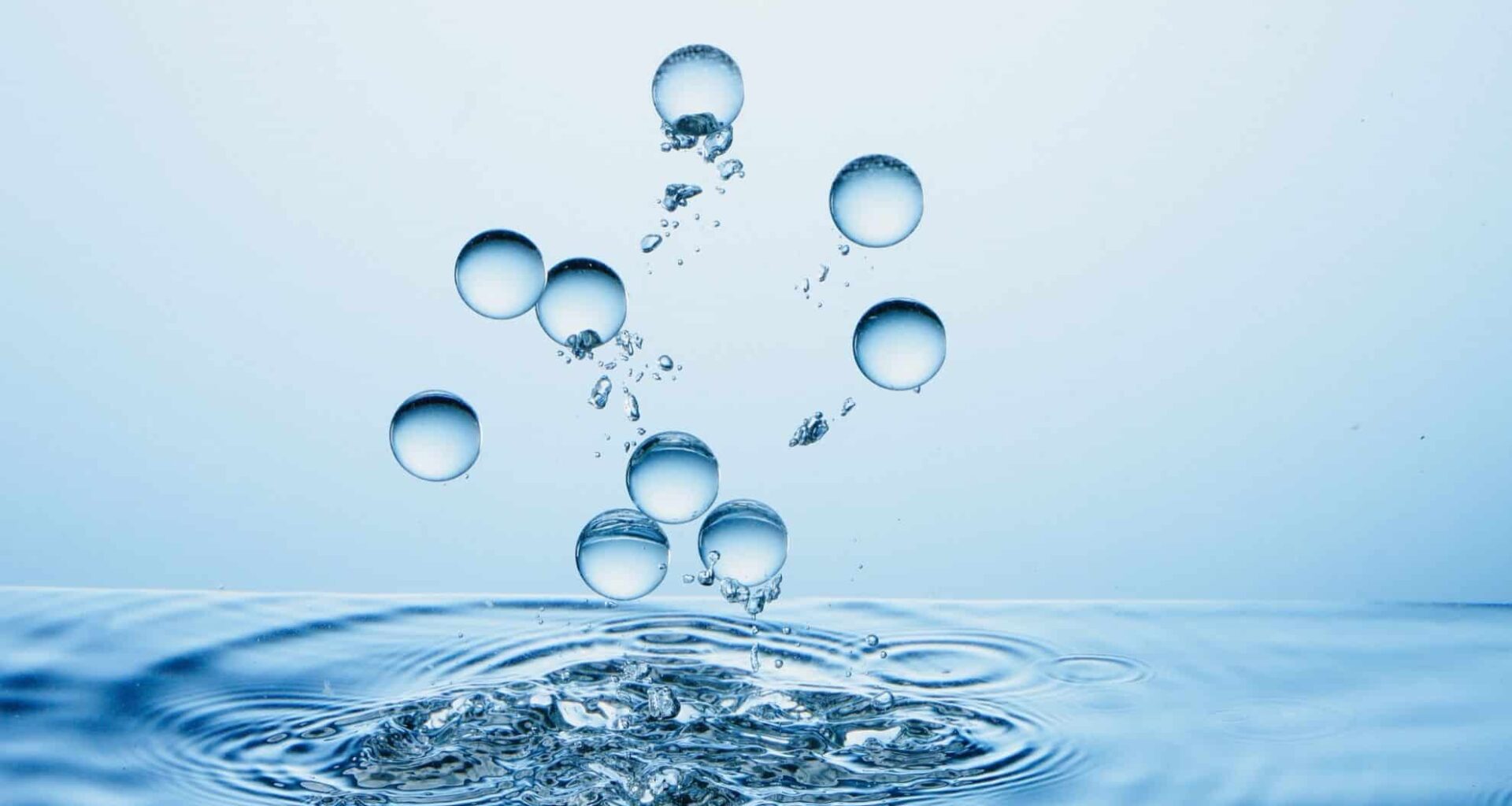 Water Droplets Splashing In Clear Blue Water