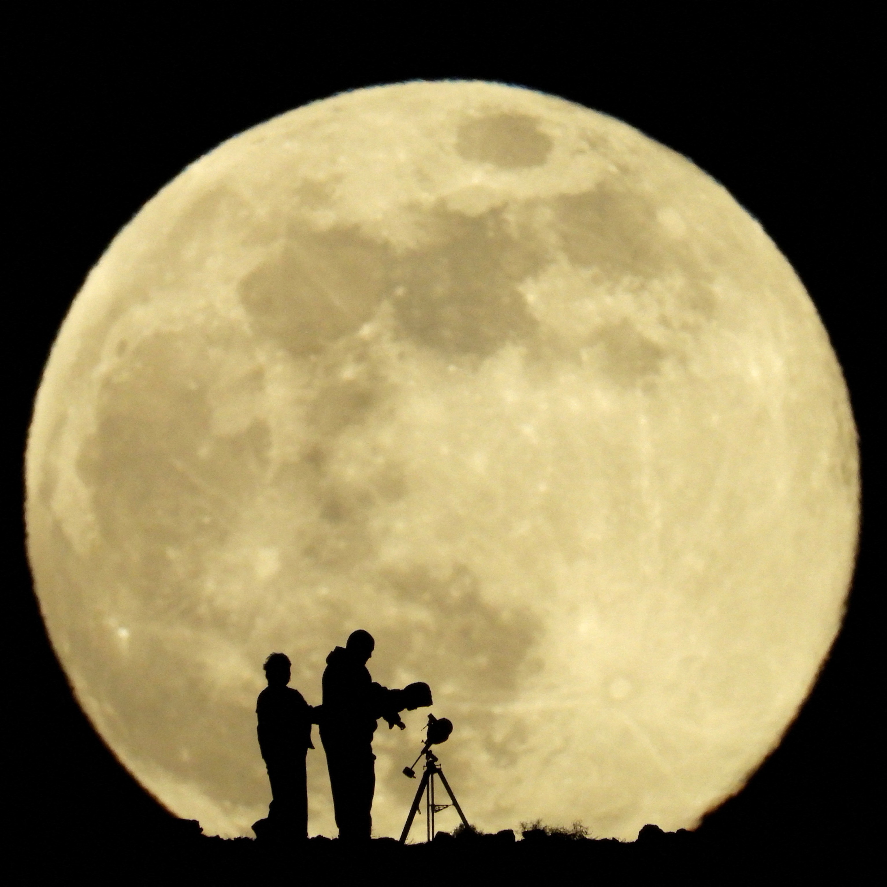 A family observing the Cold Moon with a telescope in Aguimes.