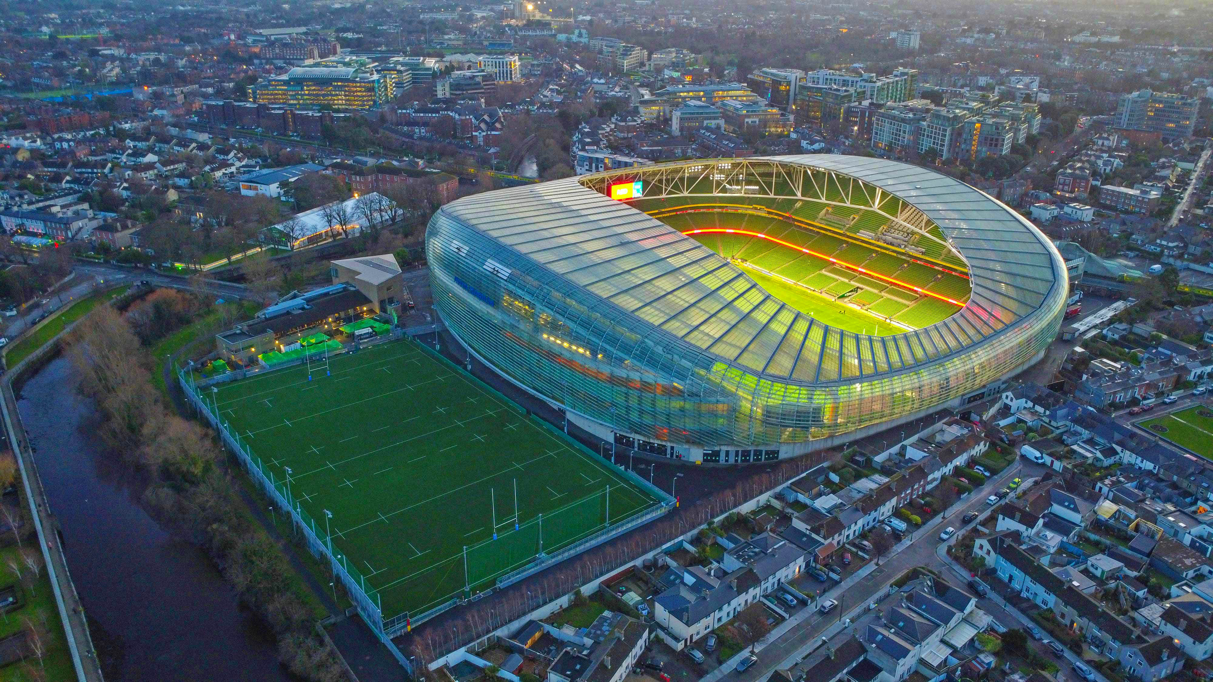 Aerial view of Aviva Stadium in Dublin with a rugby field next to it.
