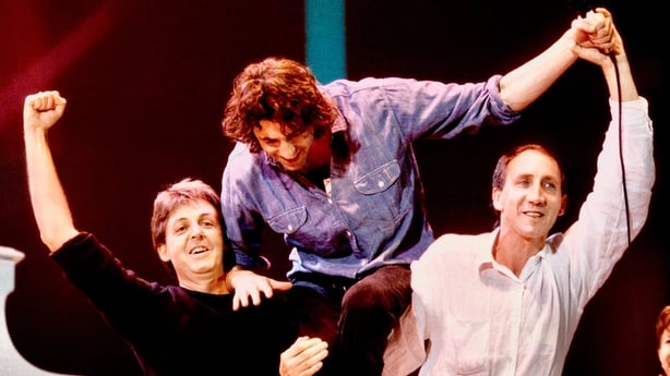 Paul McCartney and Pete Townsend carry Bob Geldof on their shoulders at Live Aid in 1985