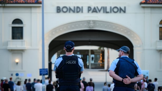 SYDNEY, AUSTRALIA - DECEMBER 24: Police stand guard as people gather during the reading of the victims' names of the Bondi mass shooting at Bondi Pavilion at Bondi Beach on December 24, 2025 in Sydney, Australia. Australians have always flocked to the sea over Christmas and New Year, with the period