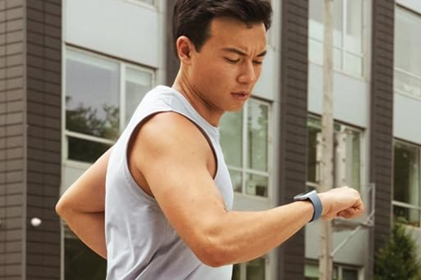 Man exercising and looking at watch