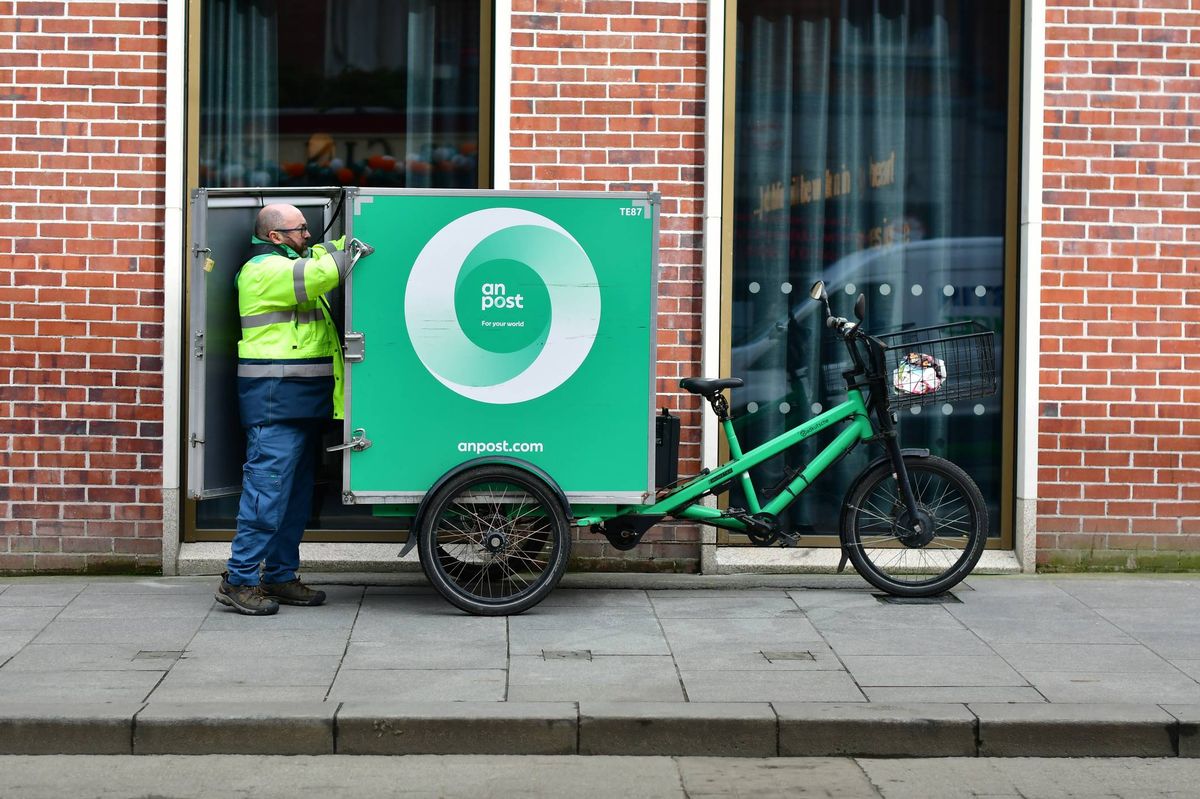 Postman at work at around 9am in Middle Abbey St, Dublin, Ireland.
