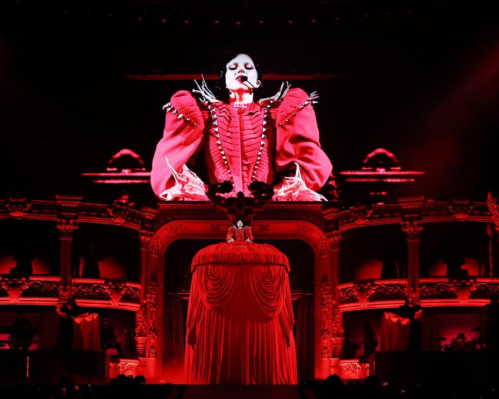 Lady Gaga on stage in a large red dress
