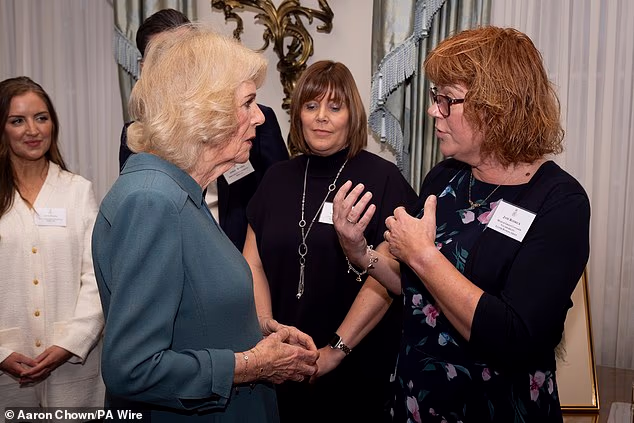 Queen Camilla talks with Jane Rodrick during a reception at Clarence House, London
