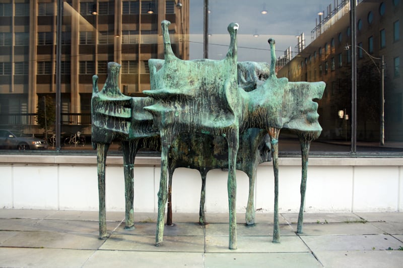 A green metal sculpture of bird-like shapes