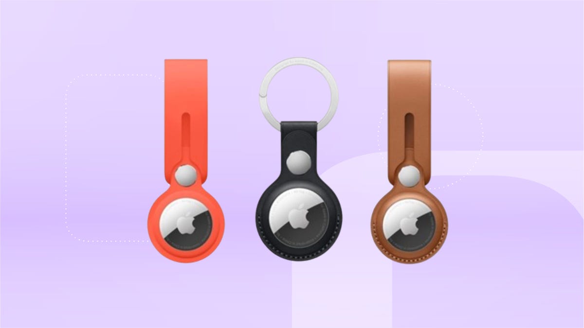 From left: bright orange, black and tan Apple AirTag keychains against lavender CNET background.
