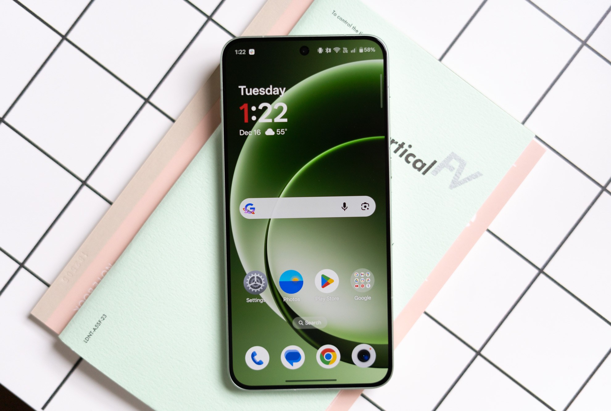 OnePlus 15R in green on a desk showing screen on