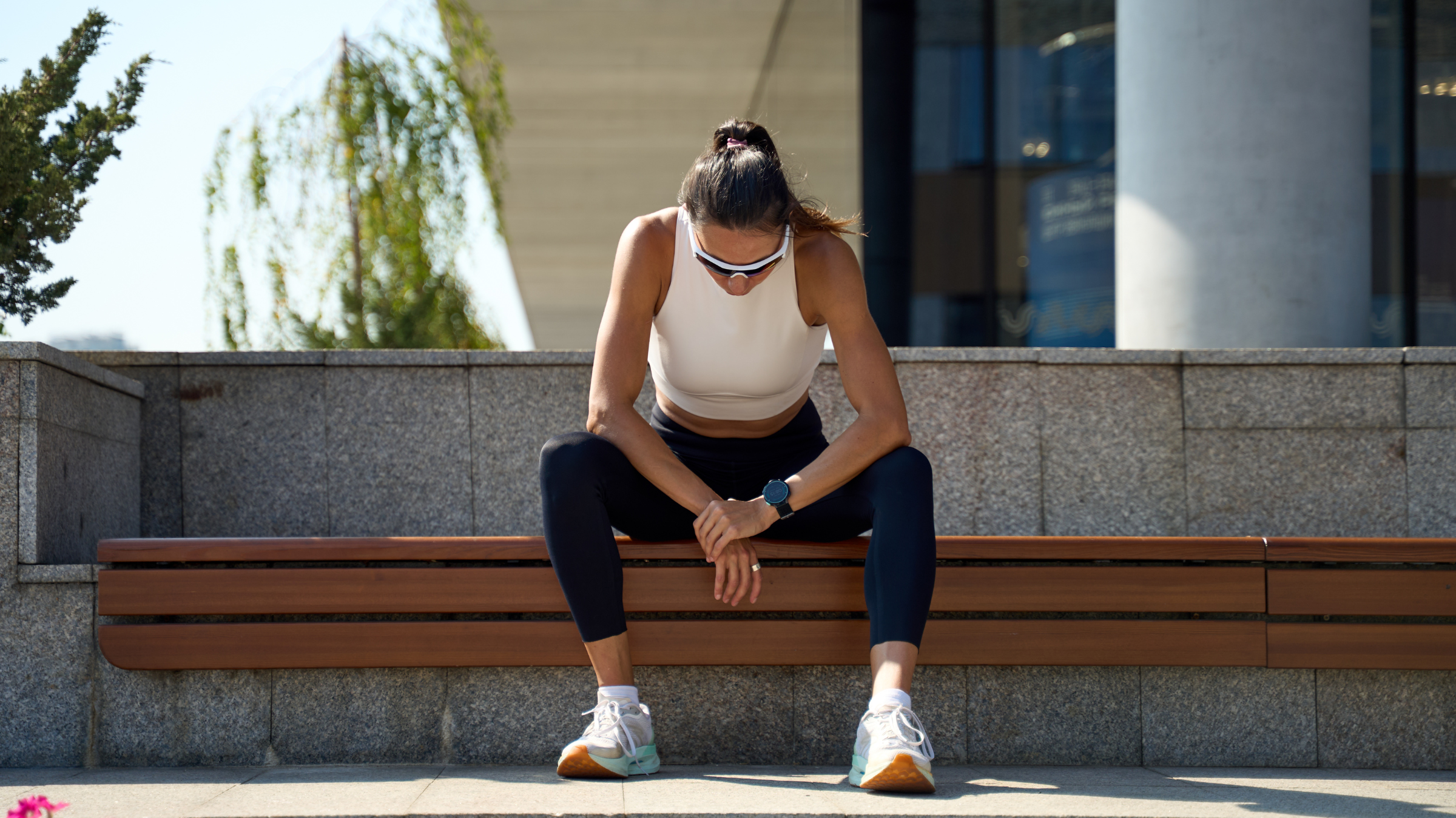a woman sitting on front steps with her hands on her knees, looking tired