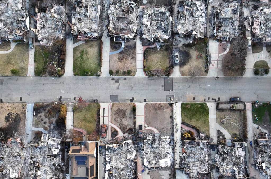 An aerial photo of a street shows an area where all but one home has been reduced to rubble.