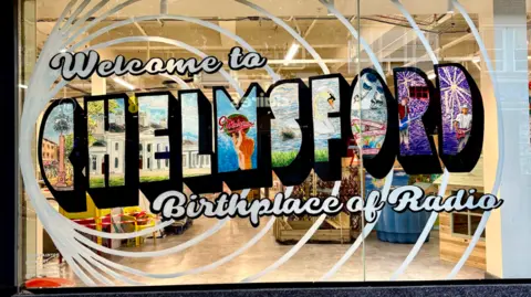 Art by Juliet Townsend Lettering displays the words Welcome to Chelmsford, Birthplace of Radio. The word Chelmsford has different paintings of Chelmsford scenes inside each letter.