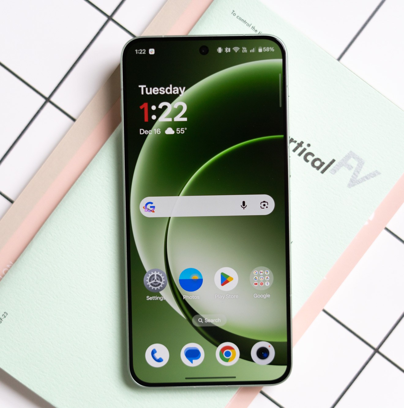 OnePlus 15R in green on a desk showing screen on