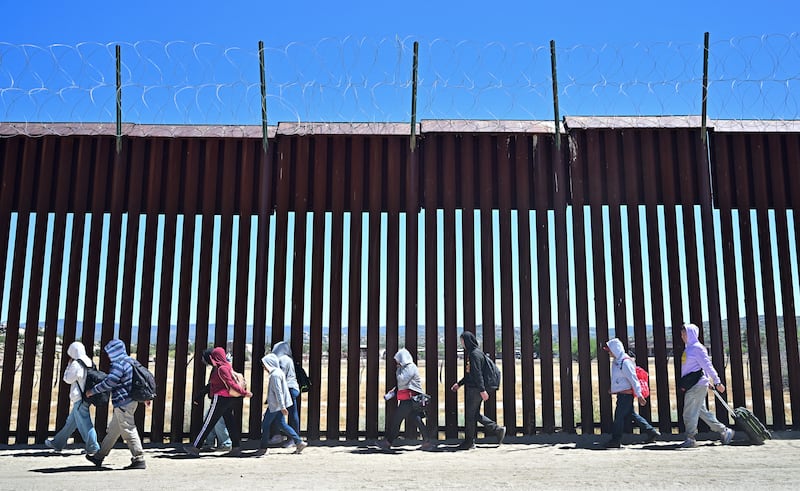 Migrants walk on the US side of the border wall after crossing from Mexico last year. Photograph: Frederic J Brown/AFP/Getty Images