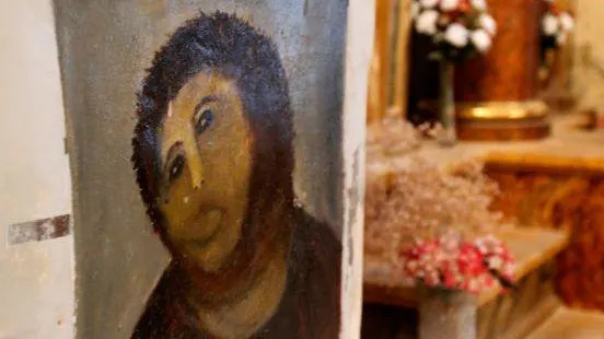 A photograph of Cecilia Giménez's restoration of Elias Garcia Martinez's Ecce Homo painting with a church visible in the background.
