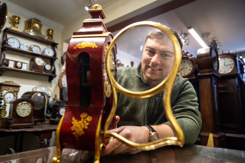 Robin Stokes with a mantel clock inside Stokes Clocks on MacCurtain Street. Picture: Chani Anderson