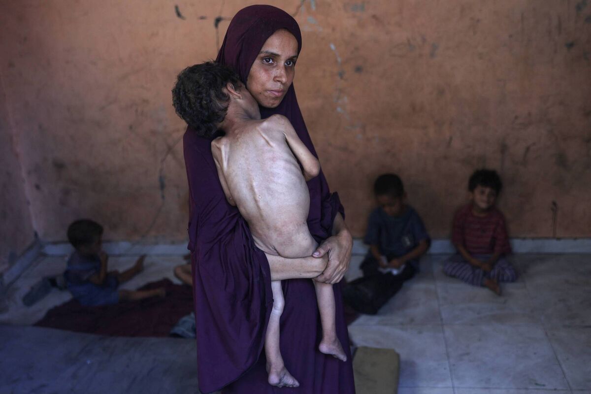 Naeema, a 30-year-old Palestinian mother, carries her malnourished two-year-old son Yazan in their damaged home in the Al-Shati refugee camp, west of Gaza City, in July. Aid agencies are still not allowed to enter an area where there remains serious humanitarian problems, not least for children. Photo: Omar al-Qattaa/AFP via Getty Images